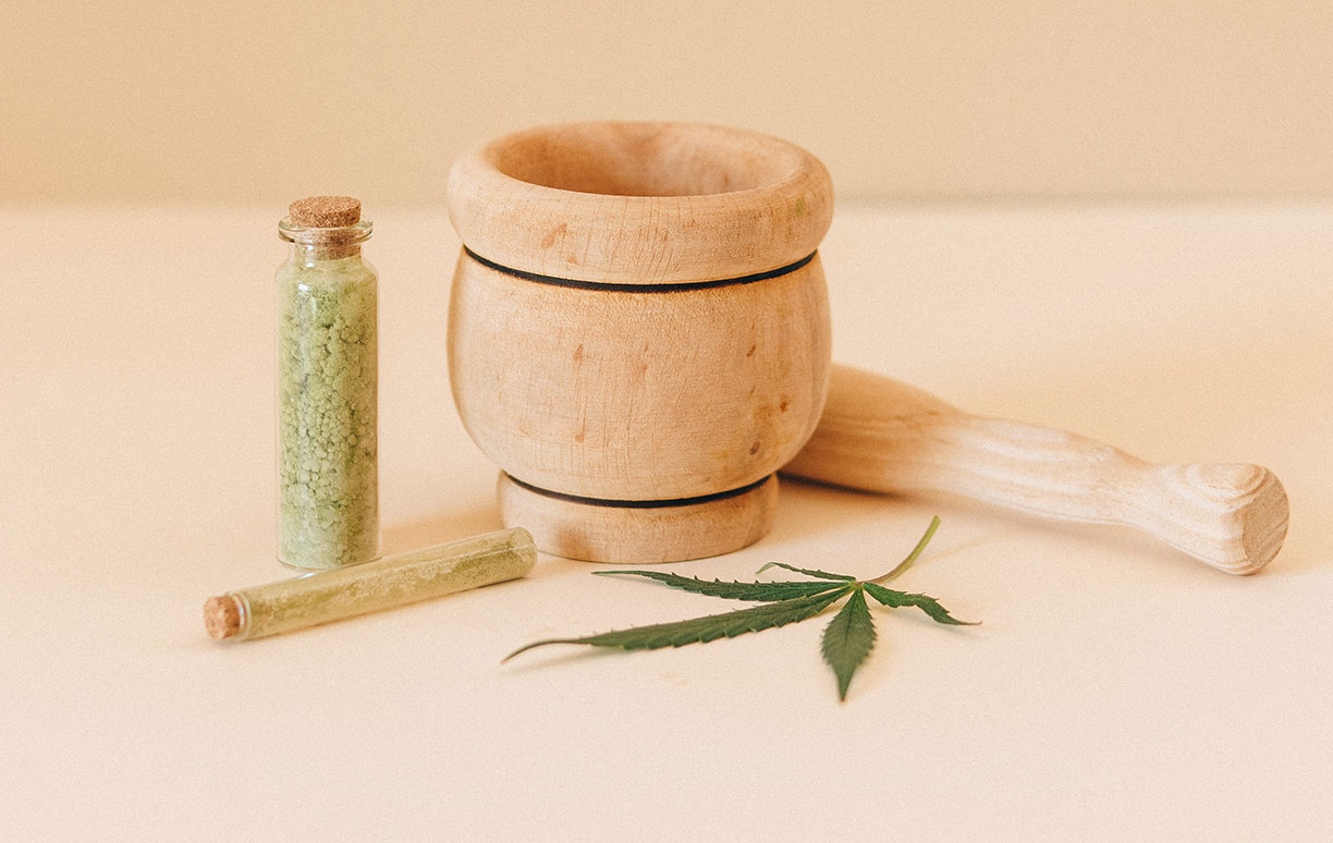 Bottle of Cannabis Beside Mortar and Pestle